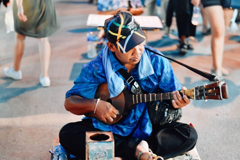 Man Sitting Playing Instrument On Walking Street Chiang Mai