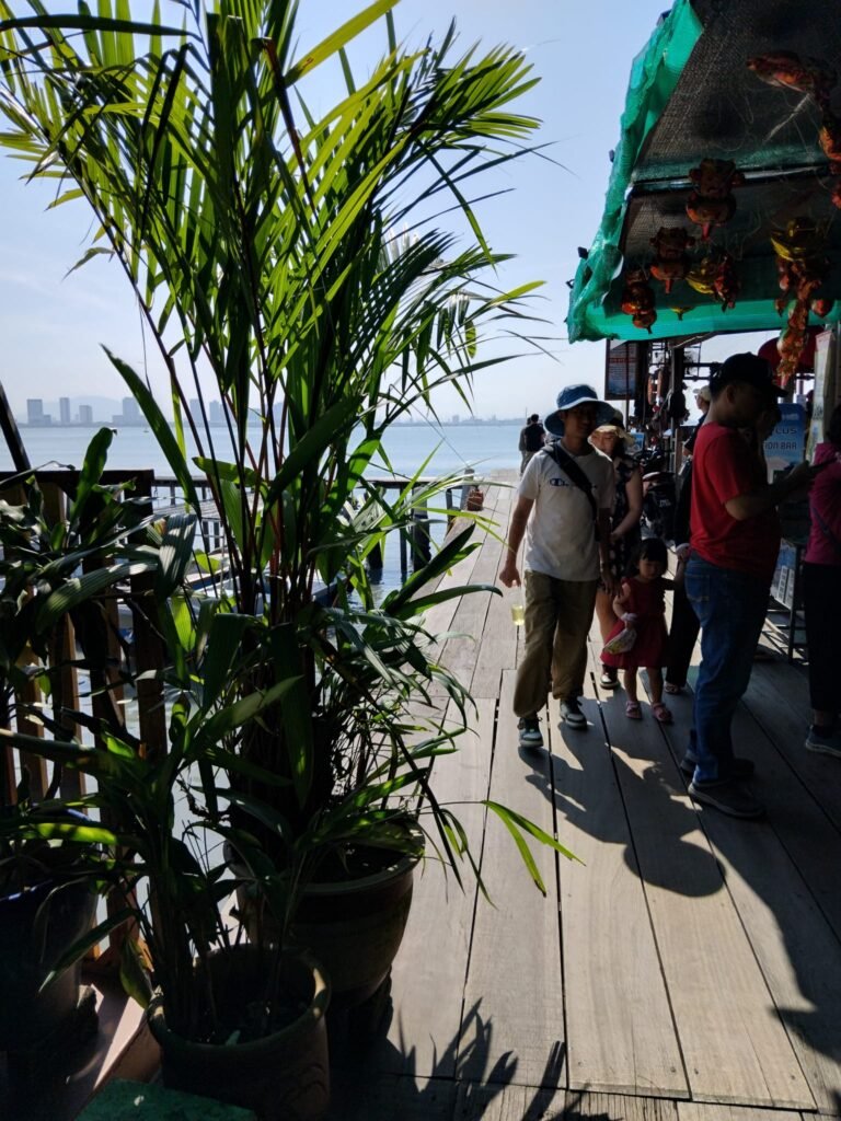 Wooden Pier With Tourists At End Of Chew Jetty