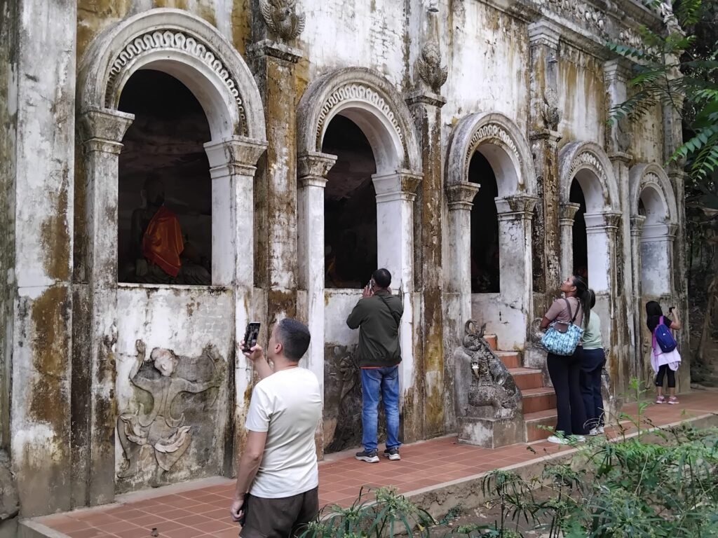 Visitors Taking Photographs Of Old Temple