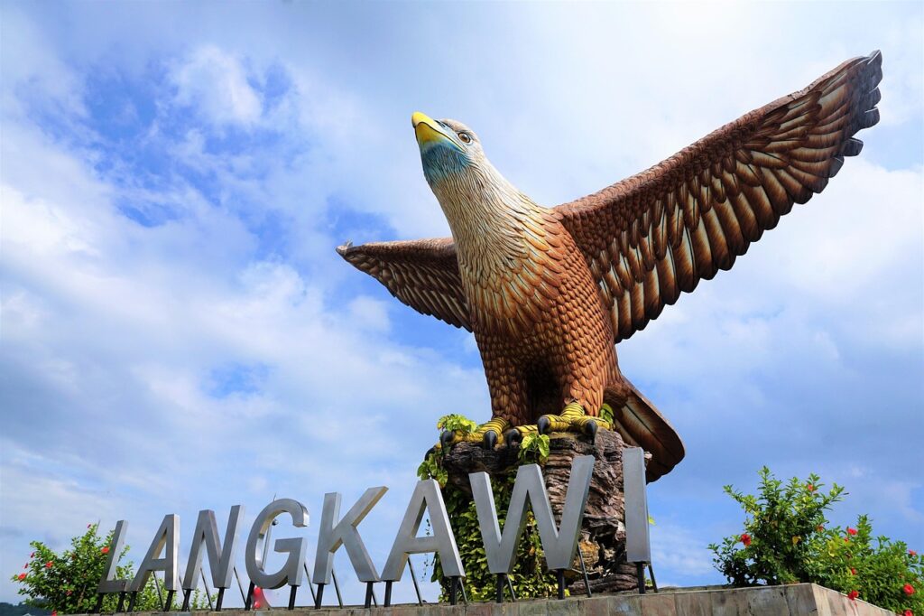 Langkawi Eagle Square statue with "LANGKAWI" sign against a blue sky