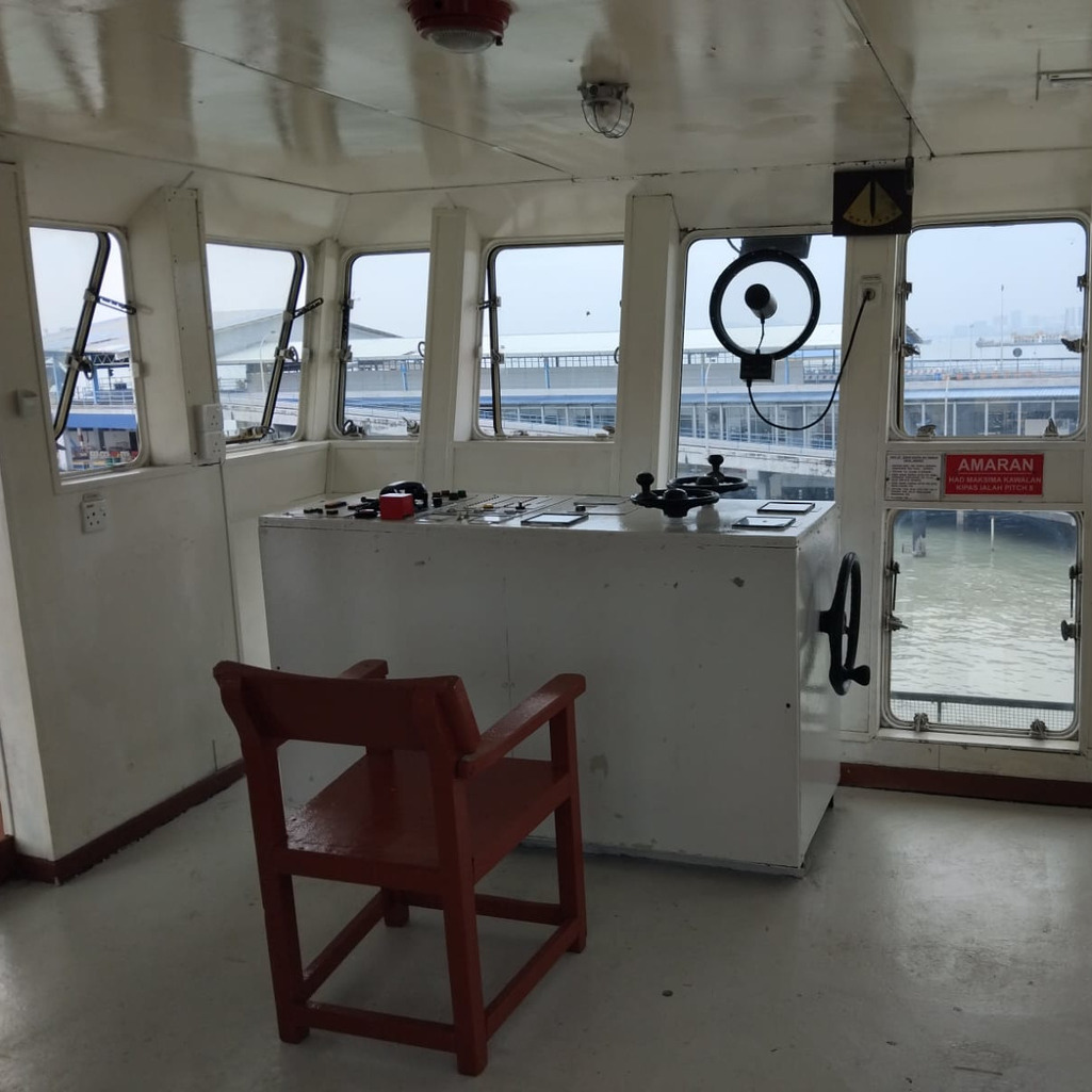 Penang Ferry Museum: Ferry control room with steering wheel and harbor view.