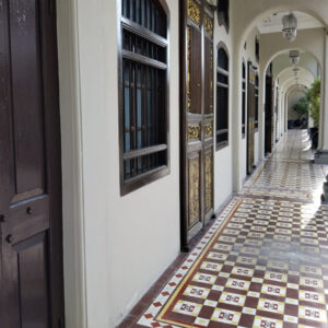 Seven Terraces George Town: A corridor with patterned tile floor and arched doorways.